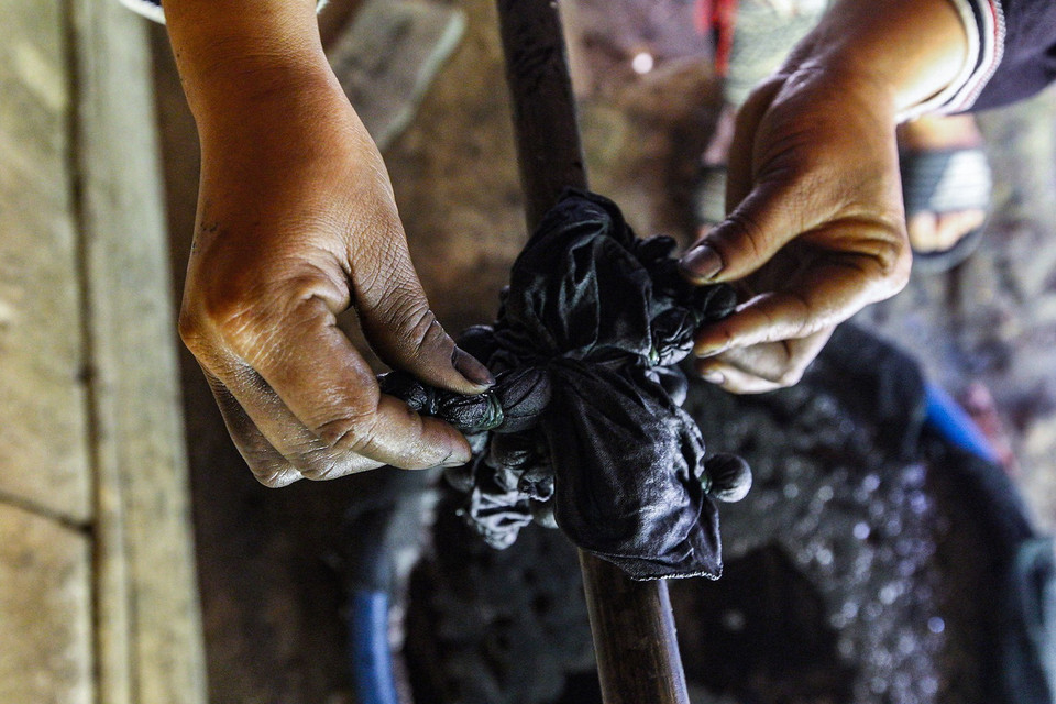 Công đoạn nhuộm chàm cho vải thổ cẩm. (Ảnh: Trọng Đạt/TTXVN)