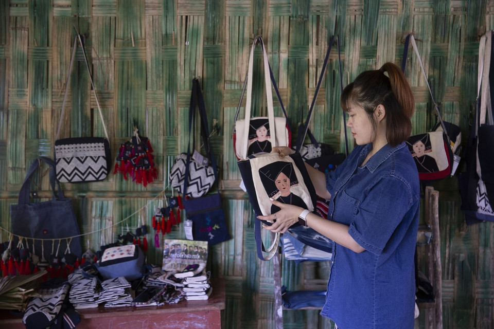 Du khách chọn mua các sản phẩm thổ cẩm của người Dao Tiền ở bản Sưng của xã Cao Sơn, huyện Đà Bắc (Hòa Bình). (Ảnh: Trọng Đạt/TTXVN)