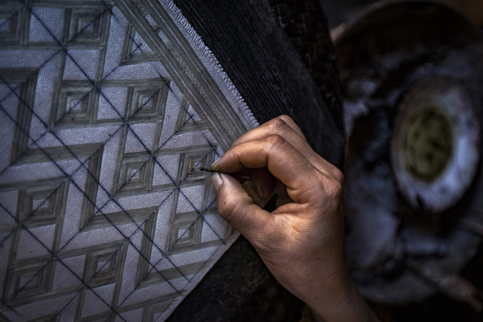 In hoa văn bằng sáp ong lên vải thổ cẩm. (Ảnh: Trọng Đạt/TTXVN)