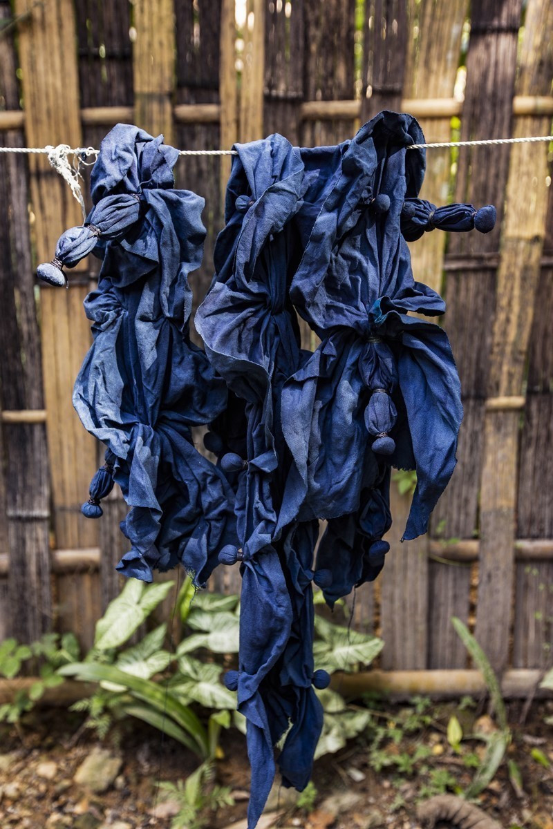 Công đoạn nhuộm vải thường mất thời gian do vải được ngâm trong nước chàm cứ khoảng 20 phút sẽ được vớt ra vắt khô rồi đem phơi nắng, khi vải khô lại cho vào ngâm tiếp trong nước chàm. Việc này lặp đi lặp lại nhiều lần cho đến khi có được màu chàm ưng ý. (Ảnh: Trọng Đạt/TTXVN)