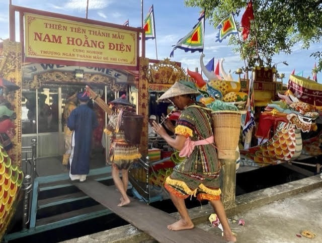 Đội hầu bóng, người phục dịch và đông đảo khách hành hương tham gia cung nghinh Thánh Mẫu đến Điện Huệ Nam. (Ảnh: Mai Trang/TTXVN)