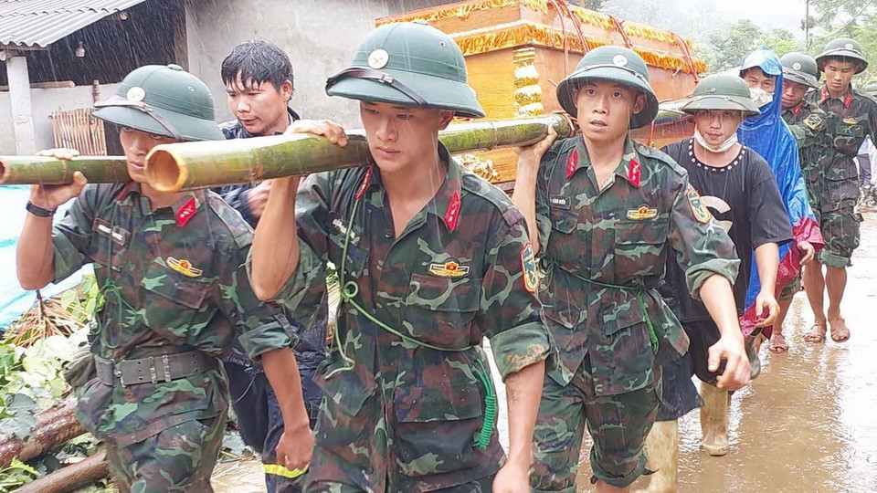 Bộ đội đưa linh cữu nạn nhân để gia đình mai táng. (Ảnh: TTXVN phát)