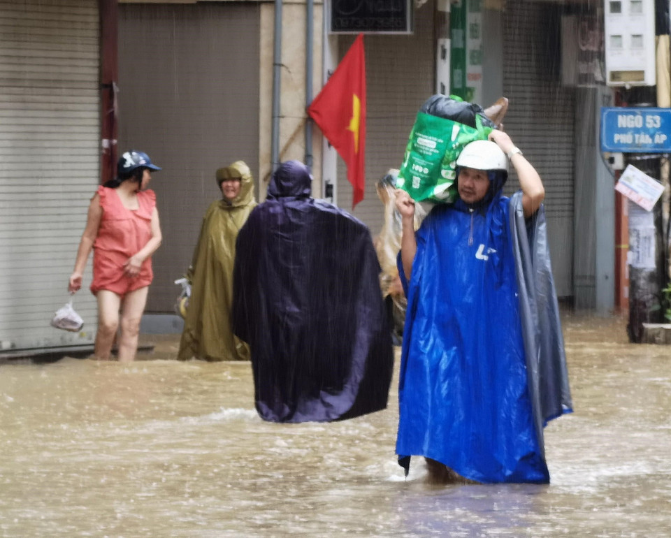 Đã rất lâu rồi, người ta mới lại thấy cảnh dân các phường ven sông của Hà Nội lội bì bõm trong dòng nước lũ. (Ảnh: Thanh Tùng/TTXVN)