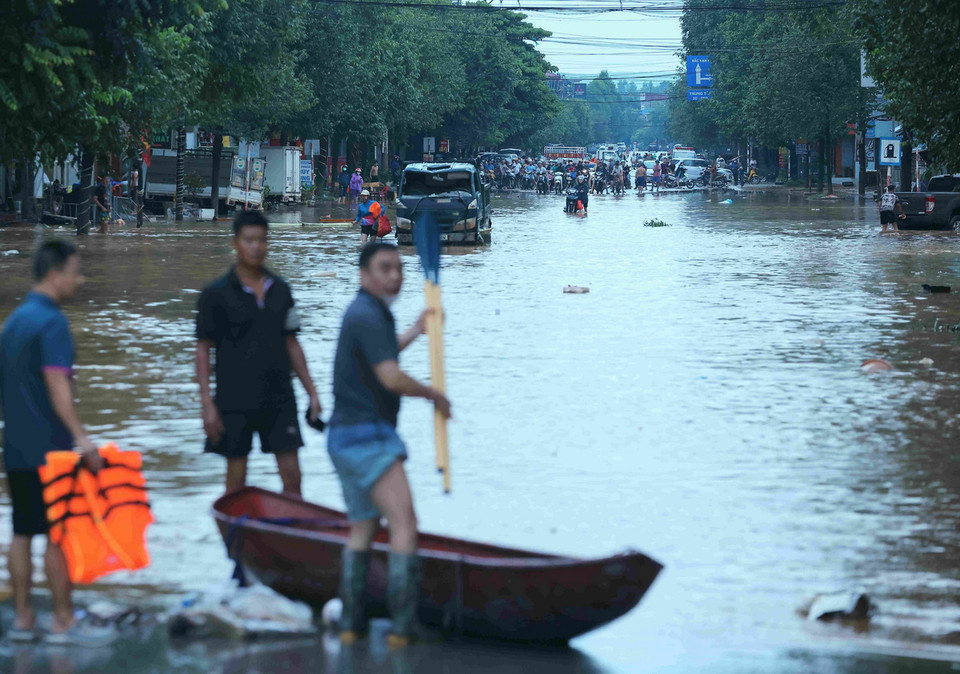 Nước ngập nhiều tuyến đường khiến việc di chuyển của người dân gặp nhiều khó khăn. (Ảnh: Hoàng Hiếu/TTXVN)