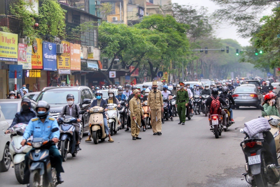 Lực lượng chức năng điều hướng giao thông trên phố Tôn Thất Tùng. (Ảnh: Tuấn Đức/TTXVN)