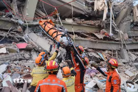 Lực lượng cứu hộ Trung Quốc và đội cứu hộ dân sự của Ramunion Rescue giải cứu thành công thai phụ mắc kẹt trong đống đổ nát của tòa nhà ở thành phố Mandalay (Myanmar) ngày 31/3/2025. (Ảnh: THX/TTXVN)