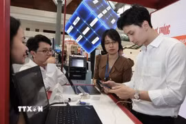 Hướng dẫn khách hàng làm sử dụng dịch vụ online tại Hội nghị Chuyển đổi Số ngành Ngân hàng năm ngoái. (Ảnh: Trần Việt/TTXVN)