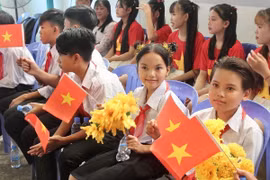 Học sinh con em kiều bào phấn khởi tham dự lễ kỷ niệm. (Ảnh: Quang Anh/TTXVN)