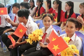Học sinh con em kiều bào phấn khởi tham dự lễ kỷ niệm. (Ảnh: Quang Anh/TTXVN)