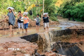 Người dân tại vùng bị ảnh hưởng bởi lũ lụt ở Bắc Sumatra (Indonesia), nhận hàng cứu trợ ngày 2/12/2025. (Ảnh: THX/TTXVN)