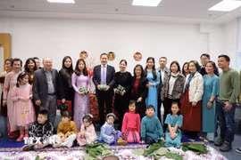 Ông Đỗ Minh Hùng, Đại sứ Việt Nam tại Anh (đứng giữa), cùng với Ban Tổ chức và các đội tham gia hội thi gói bánh chưng. (Ảnh: Hữu Tiến/TTXVN)