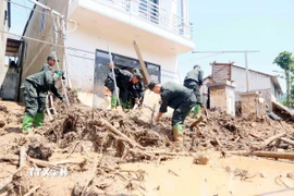 Lực lượng Công an được huy động để giúp nhân dân xã Chiềng Sơ nhanh chóng khắc phục hậu quả của lũ ống, lũ quét. (Ảnh: Quang Quyết/TTXVN)