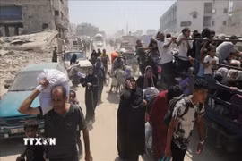 Người dân Palestine nhận hàng viện trợ từ UNRWA tại Dải Gaza. (Ảnh: IRNA/TTXVN)