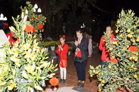 Người Việt tại Lào dẫn con cháu đến chùa lễ Phật dịp đầu năm để gìn giữ nét văn hóa truyền thống tốt đẹp của người Việt Nam. (Ảnh: Xuân Tú/TTXVN)