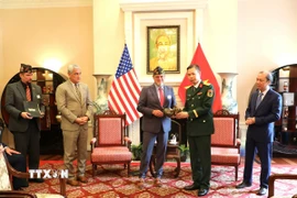Đại diện VFW (trái) trao kỷ vật cho phía Việt Nam. (Ảnh: Ngọc Quang/TTXVN)