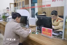 Người dân đến nộp tiền vi phạm tại một bộ phận xử lý phạt nguội qua camera giám sát giao thông. (Ảnh: Đinh Thùy/TTXVN)