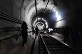 Hành khách di tản khỏi tàu điện ngầm qua một đoạn đường hầm sau khi hỏa hoạn xảy ra hôm 31/5. (Nguồn: Yonhap/The Korea Times)