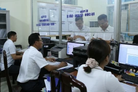 Bộ phận tiếp nhận và trả kết quả phường Trần Hưng Đạo, thành phố Nam Định giải quyết thủ tục hành chính cho người dân. (Ảnh: Công Luật/TTXVN)