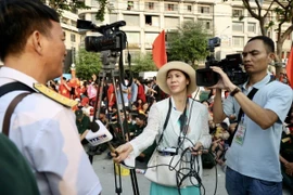 Phóng viên Thông tấn xã Việt Nam tác nghiệp tại Lễ diễu binh, diễu hành kỷ niệm 50 năm Ngày Giải phóng miền Nam, thống nhất đất nước. (Ảnh: Lưu Niệm/TTXVN)