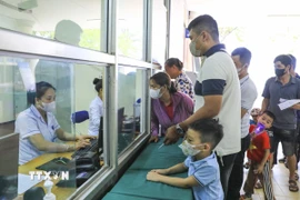 Phụ huynh đưa trẻ đến thăm khám tại Bệnh viện Đa khoa tỉnh Điện Biên.​ (Ảnh: Xuân Tư/TTXVN)