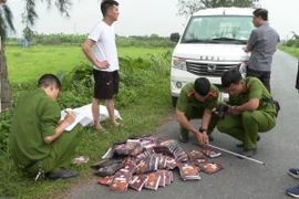 Cơ quan công an thu giữ tang vật vụ án. (Ảnh: TTXVN phát)