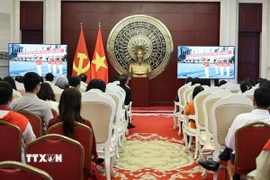 Cán bộ, nhân viên Đại sứ quán và cộng đồng người Việt tại Trung Quốc theo dõi Lễ diễu binh, diễu hành kỷ niệm 80 năm Cách mạng Tháng Tám và Quốc khánh 2/9 qua màn hình nhỏ. (Ảnh: Hải Yến/TTXVN)