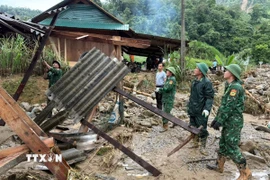 Cán bộ, chiến sỹ Đồn biên phòng Tri Lễ huy động hỗ trợ người dân khắc phục hậu quả mưa lũ trên địa bàn tỉnh Nghệ An. (Ảnh: TTXVN phát)