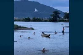 (Ảnh cắt từ clip) Người dân nỗ lực tìm kiếm tại điểm ba học sinh bị đuối nước. (Ảnh: TTXVN phát)