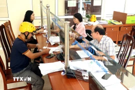 Người dân đến làm thủ tục hành chính tại Bảo hiểm xã hội tỉnh Hưng Yên. (Ảnh: Đinh Văn Nhiều/TTXVN)