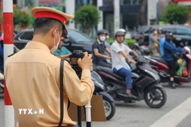 Sử dụng camera lưu động ghi hình hành vi vi phạm là một biện pháp nhằm đảm bảo minh bạch khi phạt nguội, đồng thời tăng tính răn đe đối với người tham gia giao thông. (Ảnh: TTXVN phát)