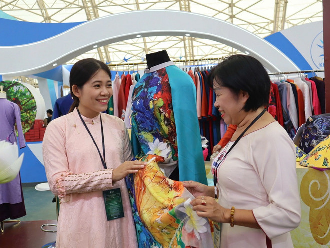 Người dân được nghe giới thiệu, quảng bá về sản phẩm tại Hội chợ. (Ảnh: Vietnam+) 5-4741.jpg