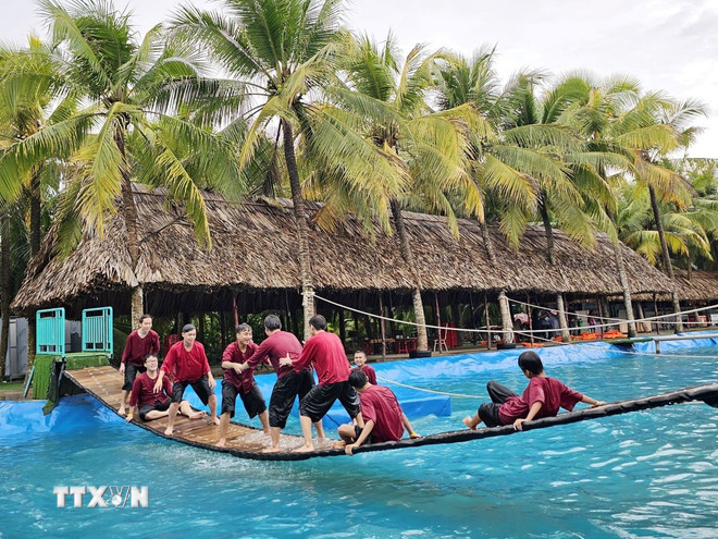 Khách du lịch trải nghiệm trò chơi vận động tại Khu du lịch Sen hồng tại xã Phú Túc, tỉnh Vĩnh Long. (Ảnh: Chương Đài/TTXVN ) ttxvn-2107-vl2.jpg
