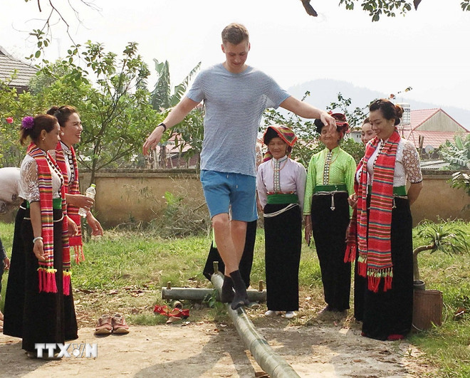 غیر ملکی سیاح ہیٹ چا فیسٹیول میں پل عبور کر رہے ہیں۔ (تصویر: Nguyen Cuong/VNA)۔ ttxvn-le-hoi-het-cha-son-la-1.jpg
