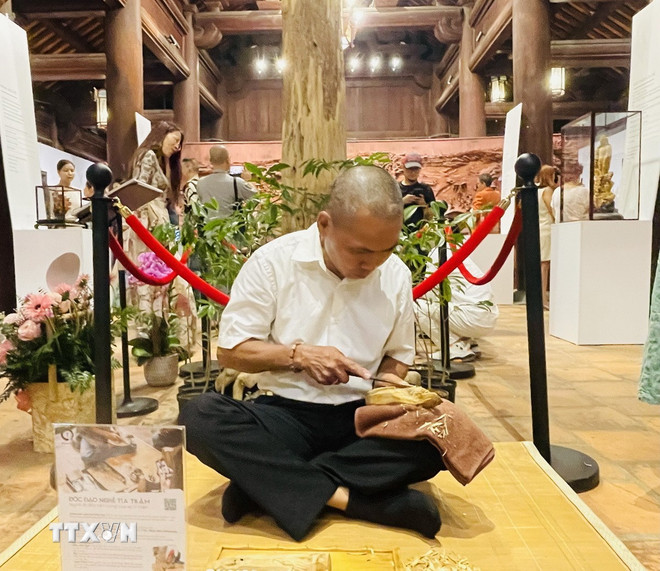 Nghệ nhân trình diễn tỉa trầm tại triển lãm. (Ảnh: Tuyết Mai/ TTXVN) ttxvn-my-thuat-1.jpg