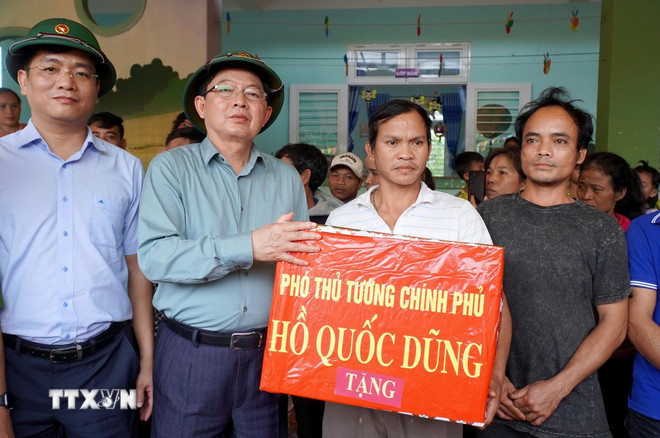 Phó Thủ tướng Hồ Quốc Dũng tặng quà cho các hộ dân xã Tây Trà Bồng. (Ảnh: Lê Phước Ngọc/TTXVN) ttxvn-pho-ttg.jpg