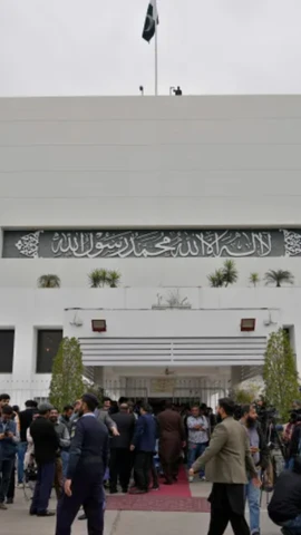 Các phóng viên và nhân viên an ninh tại cổng chính của Tòa nhà Quốc hội ở Islamabad, Pakistan. (Nguồn: AP)