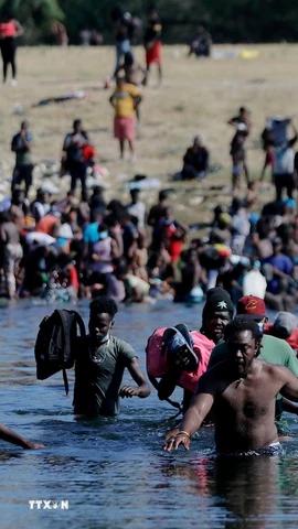 Người di cư vượt sông Rio Bravo ở biên giới Mexico để vào Mỹ. (Ảnh: THX/TTXVN)