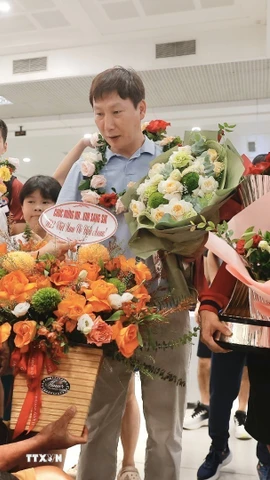 Người hâm mộ tặng hoa thầy trò huấn luyện viên Kim Sang Sik. (Ảnh: Minh Quyết/TTXVN)