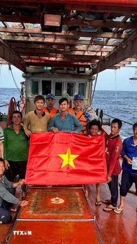 Lực lượng chấp pháp trên biển của Thành phố Hồ Chí Minh trao cờ tổ quốc và tuyên truyền IUU cho ngư dân đang đánh bắt trên biển. (Ảnh: Hoàng Nhị/TTXVN)