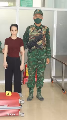 Đối tượng Nguyễn Thị Phương bị bắt giữ tại máy soi chiếu hành lý trong vali có 1 khẩu súng ngắn dạng ổ xoay, bên trong ổ đạn có 6 viên đạn đầu kim loại. (Ảnh: TTXVN phát)