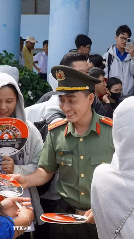 Ban Thanh niên Công an tỉnh An Giang tặng quạt tuyên truyền phòng chống ma túy đến các học sinh. (Ảnh: Văn Sĩ/TTXVN)