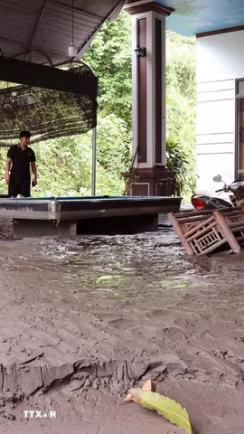 Lớp bùn đất dày khoảng 0,5m phủ kín nền nhà của một hộ dân sau mưa lớn. (Ảnh: Đức Thọ/TTXVN)