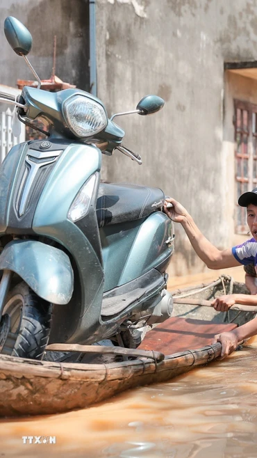 Người dân thôn Ngộ Đạo, xã Đa Phúc (Hà Nội) di chuyển tài sản khỏi vùng bị ngập. (Ảnh: Hoàng Hiếu/TTXVN)