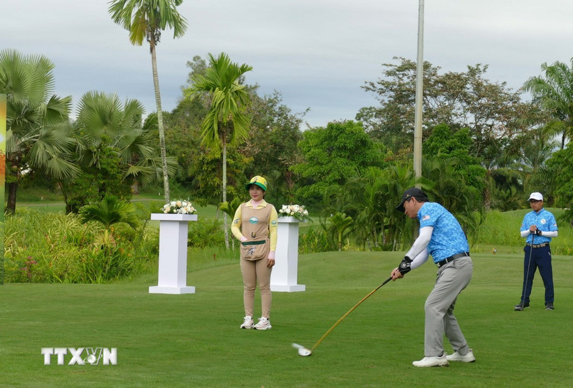 Đại sứ Việt Nam tại Lào Nguyễn Minh Tâm thực hiện cú đánh khai mạc giải đấu. (Ảnh: Xuân Tú/TTXVN)