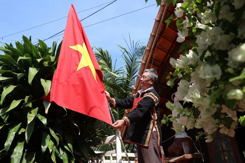 Già làng Y’Siu Byă, buôn Mduk, phường Ea Tam, thành phố Buôn Ma Thuột treo cờ Tổ quốc chào mừng 50 năm Chiến thắng Buôn Ma Thuột, giải phóng tỉnh Đắk Lắk. (Ảnh: Tuấn Anh/TTXVN)