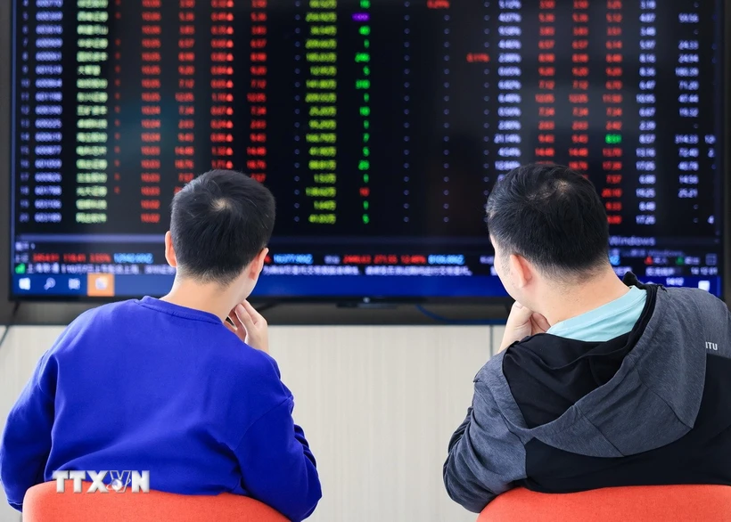 Nhà đầu tư theo dõi chỉ số chứng khoán tại tỉnh Giang Tô, Trung Quốc. (Ảnh: THX/TTXVN)