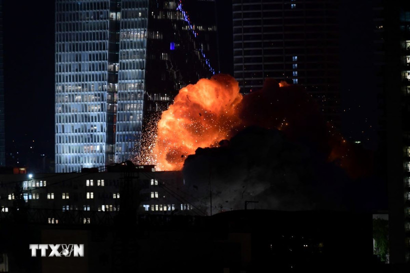 Khói lửa bốc lên từ tòa nhà bị trúng tên lửa của Iran tại Tel Aviv, Israel tối 14/6/2025. (Ảnh: THX/TTXVN)