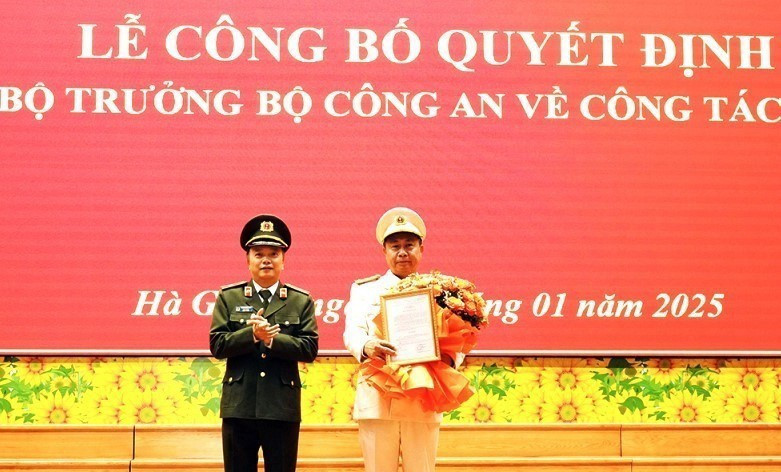 Thiếu tướng Đặng Hồng Đức, Ủy viên Đảng ủy Công an Trung ương, Thứ trưởng Bộ Công an, trao Quyết định và tặng hoa, chúc mừng Đại tá Nguyễn Đức Thuận, tân Giám đốc Công an tỉnh Hà Giang. (Ảnh: TTXVN phát)