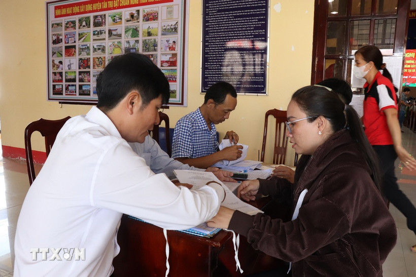Người dân xã Tân Trụ, tỉnh Tây Ninh đến nhận thông tin về giải phóng mặt bằng tỉnh lộ 827E. (Ảnh: Thanh Bình/TTXVN)