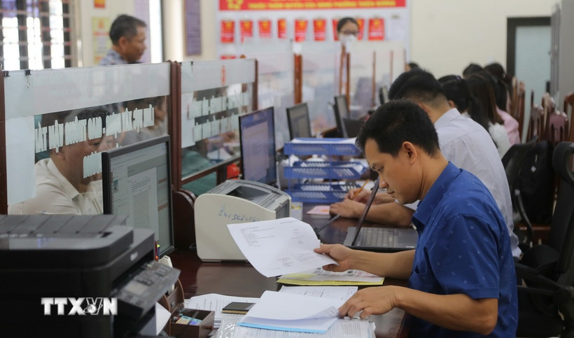 Chuyên viên lĩnh vực xây dựng, giao thông, công thương phường Thiên Hương kiểm tra thông tin hồ sơ công dân nộp. (Ảnh: Minh Thu/TTXVN)